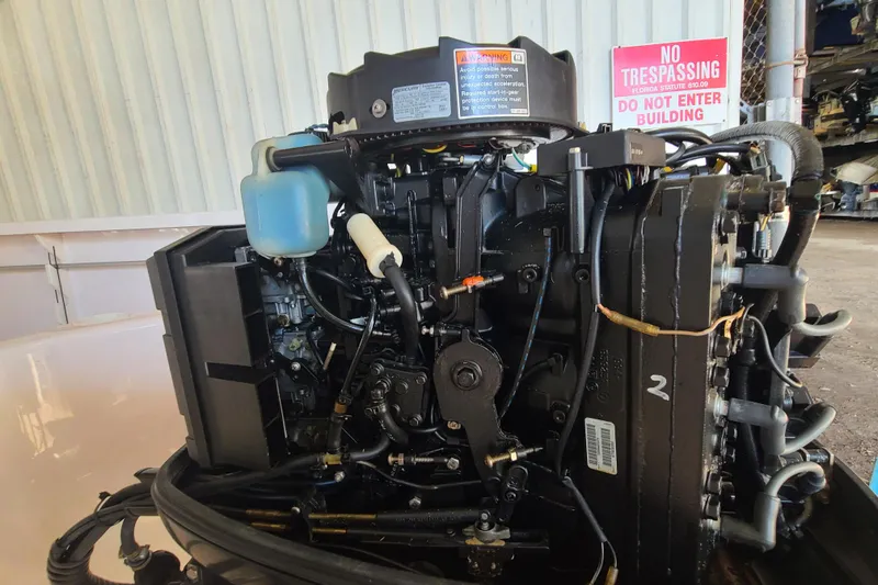 Slide: The Image of 2002 Pro-Line 22 Sport boat engine, detailed view, with warning sign in background. - 26