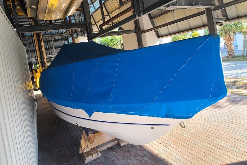 Slide: The Image of 2002 Pro-Line 22 Sport boat covered with a blue tarp in storage. - 30