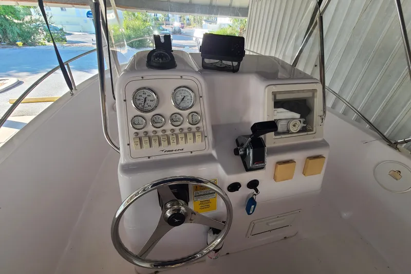 Slide: The Image of 2002 Pro-Line 22 Sport boat dashboard with steering wheel and gauges. - 9