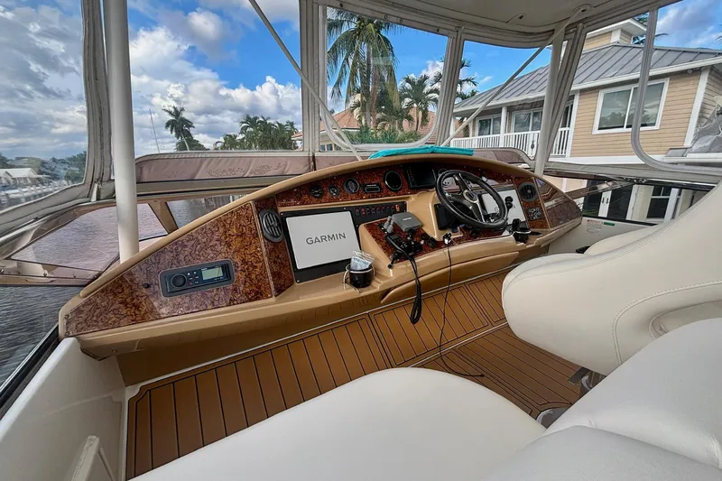 Slide: The Image of 2004 Marquis 59 yacht helm with Garmin navigation, luxurious interior, and waterfront view. - 13