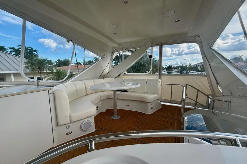 Slide: The Image of Luxurious 2004 Marquis 59 yacht interior with white seating and scenic water view. - 16