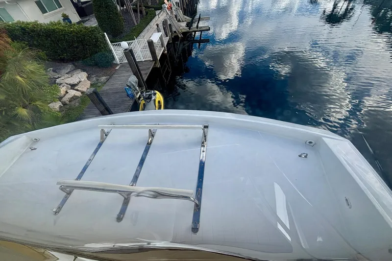Slide: The Image of 2004 Marquis 59 yacht docked by a serene waterfront with clear reflections. - 17