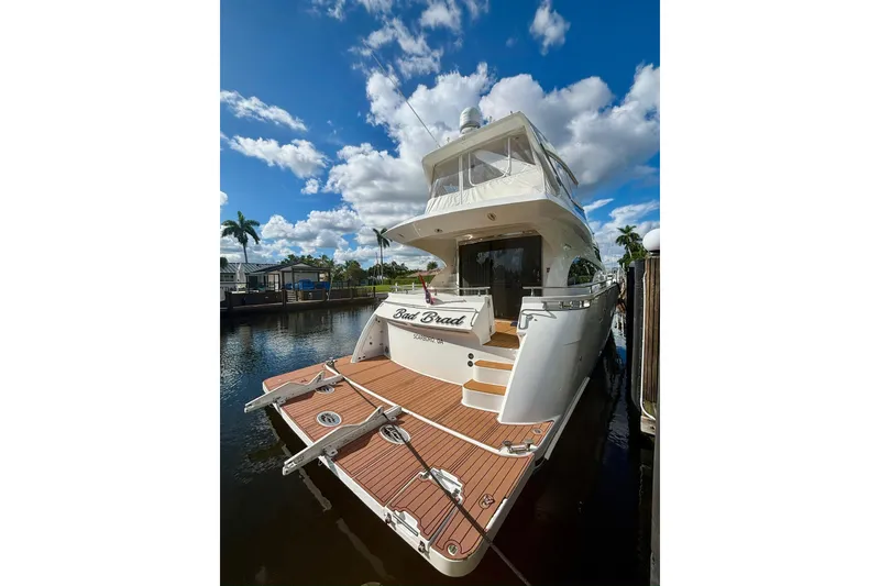 Slide: The Image of Luxury 2004 Marquis 59 yacht docked under a vibrant blue sky. - 2