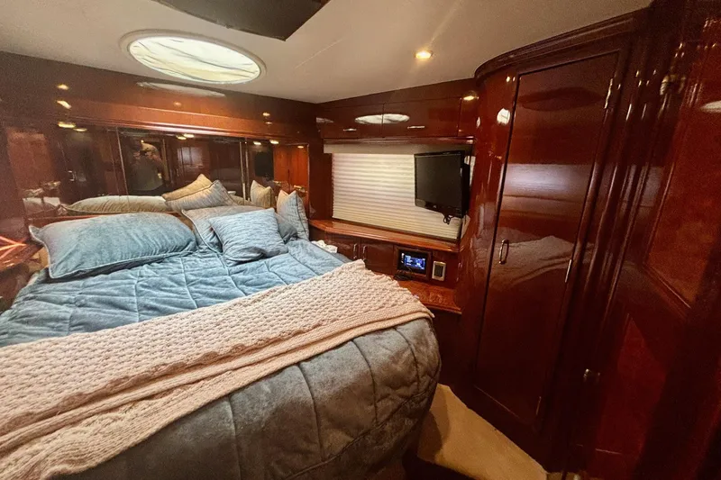Slide: The Image of Luxurious 2004 Marquis 59 yacht bedroom with plush bedding and elegant wood finishes. - 29