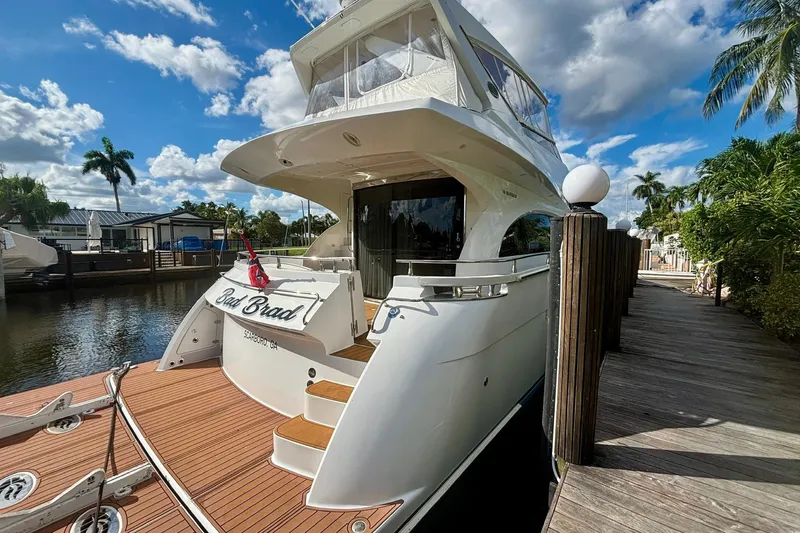 Slide: The Image of Luxury 2004 Marquis 59 yacht docked by a scenic waterfront under blue skies. - 3