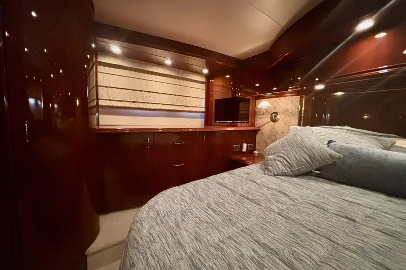 Slide: The Image of Luxurious 2004 Marquis 59 yacht bedroom with elegant wood finishes and cozy bedding. - 34
