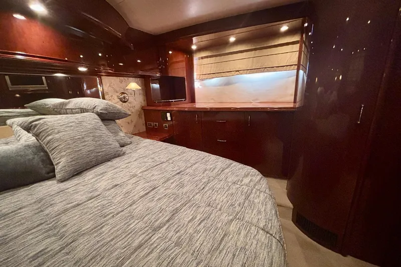 Slide: The Image of Luxurious 2004 Marquis 59 yacht bedroom with elegant wood finishes and cozy bedding. - 35