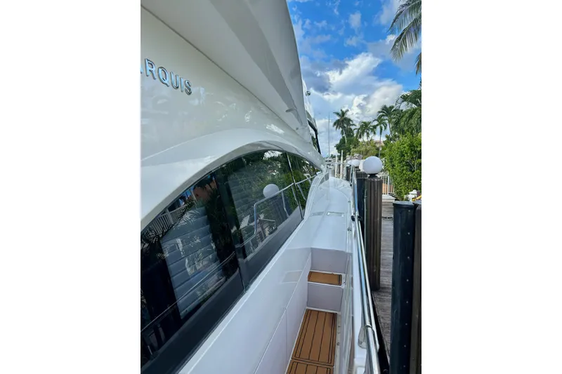 Slide: The Image of 2004 Marquis 59 yacht docked, showcasing sleek design and tropical surroundings. - 6