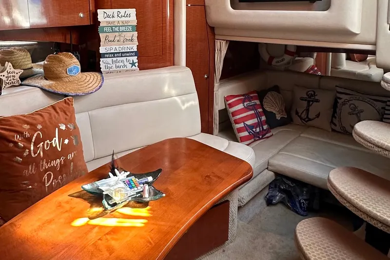 Slide: The Image of Interior of 2005 Sea Ray 320 Sundancer with nautical decor and cozy seating area. - 10