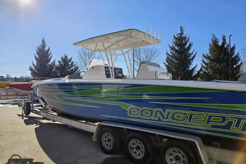 Slide: The Image of 2014 Concept 36' CC boat on trailer, blue and green design, clear sky background. - 24