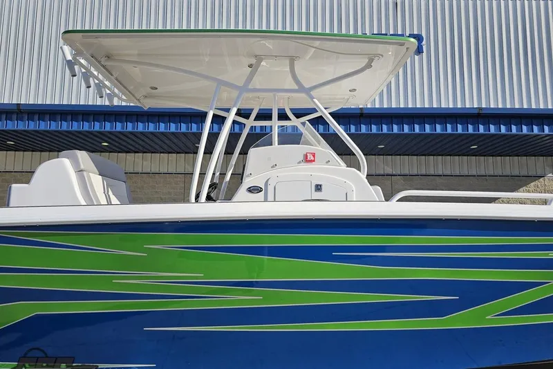 Slide: The Image of 2014 Concept 36' CC boat with vibrant green and blue design, docked near a building. - 4
