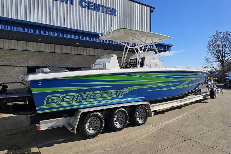 Slide: The Image of 2014 Concept 36' CC boat with blue and green design on a trailer outside a building. - 9