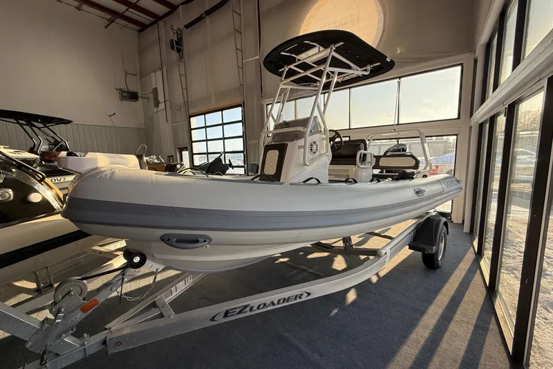 The Image of 2026 Highfield Sport 560 boat on trailer in showroom, side view. - 0