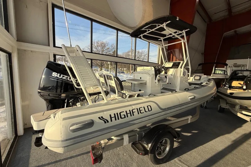Slide: The Image of 2026 Highfield Sport 560 boat with Suzuki engine displayed indoors. - 1