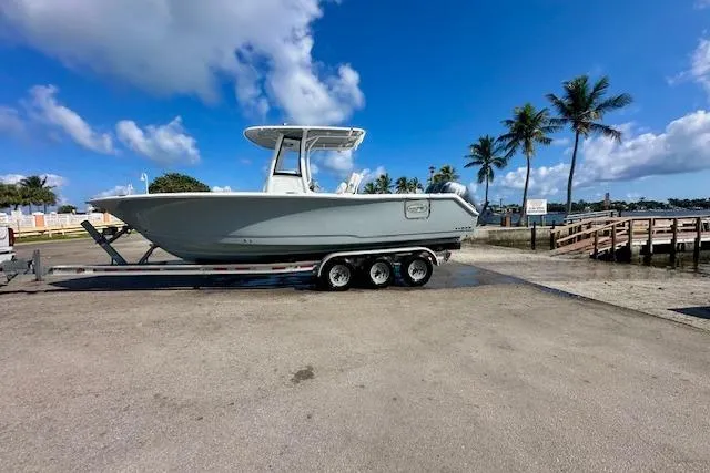 Slide: The Image of 2018 Sea Hunt Gamefish 27 Coffin Box boat on trailer, parked near palm trees. - 7