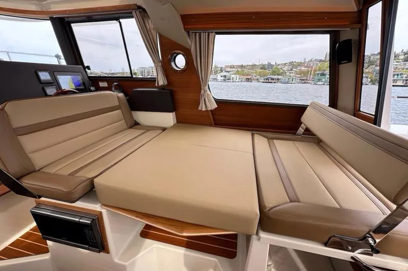 Slide: The Image of 2021 Ranger Tugs R-29 S interior with wood accents and cabin view. - 25