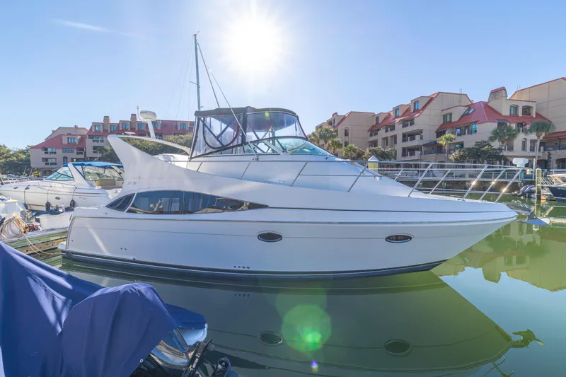 The Image of 2006 Carver 36 Mariner yacht docked in sunny marina with buildings in background. - 0