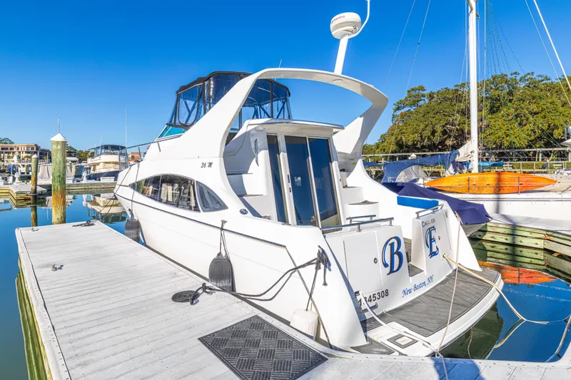Slide: The Image of 2006 Carver 36 Mariner yacht docked at a marina under clear blue skies. - 2