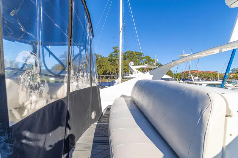 Slide: The Image of 2006 Carver 36 Mariner yacht with white seating and clear enclosure, docked under blue sky. - 20