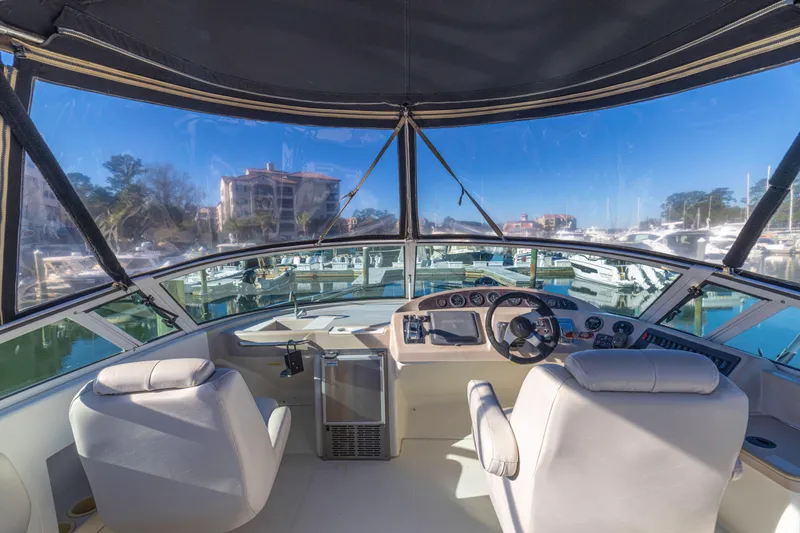 Slide: The Image of 2006 Carver 36 Mariner yacht cockpit with marina view, featuring modern controls and seating. - 28