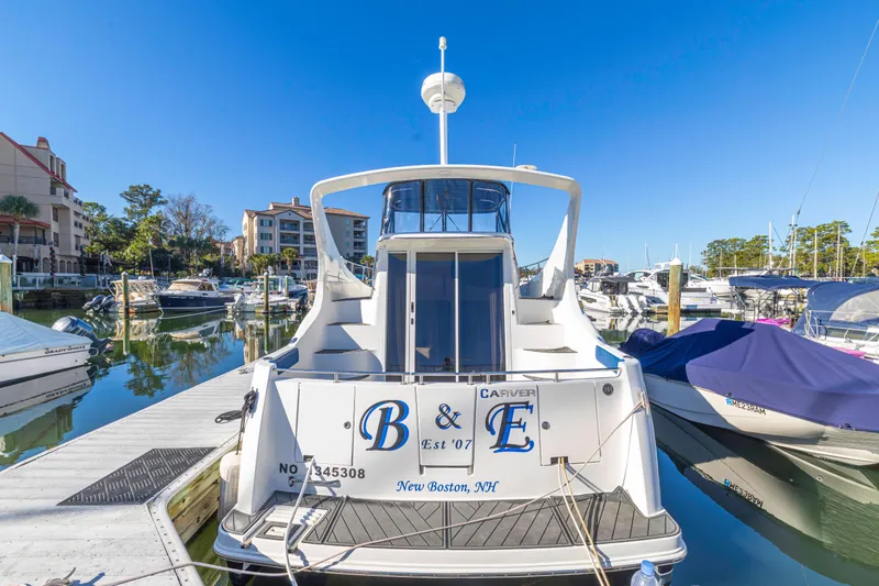 Slide: The Image of 2006 Carver 36 Mariner yacht docked at marina, clear blue sky, waterfront view. - 5