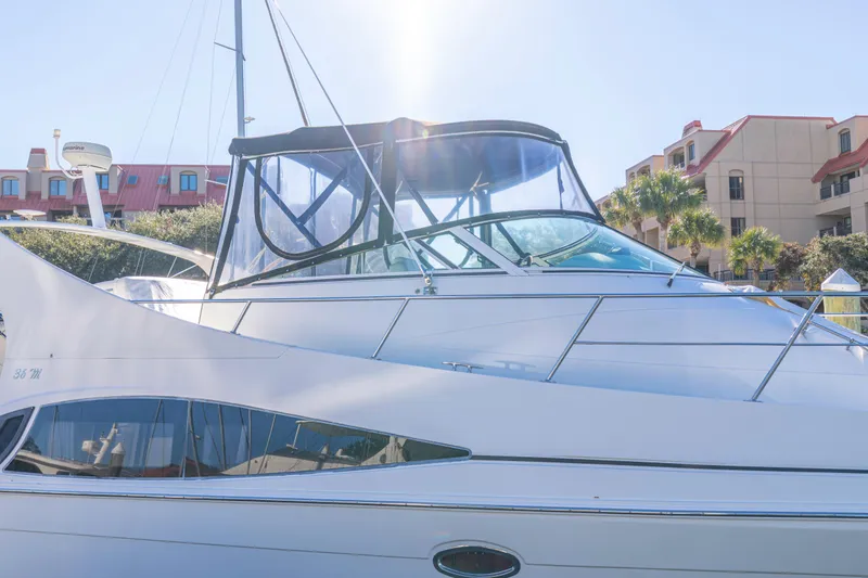 Slide: The Image of 2006 Carver 36 Mariner yacht docked, with sunlit canopy and modern design. - 6
