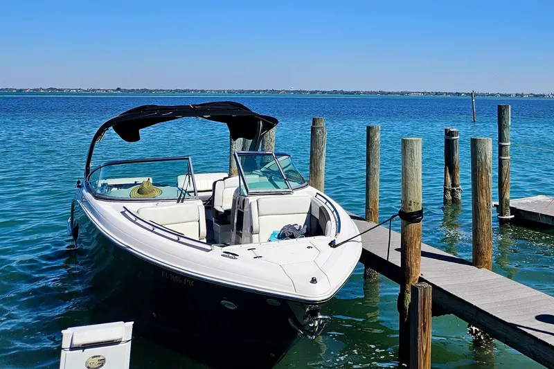 Slide: The Image of 2014 Regal 3200 Bowrider docked on clear blue water under a sunny sky. - 1