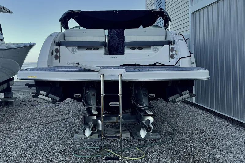 Slide: The Image of 2014 Regal 3200 Bowrider boat with dual propellers, docked on gravel. - 12