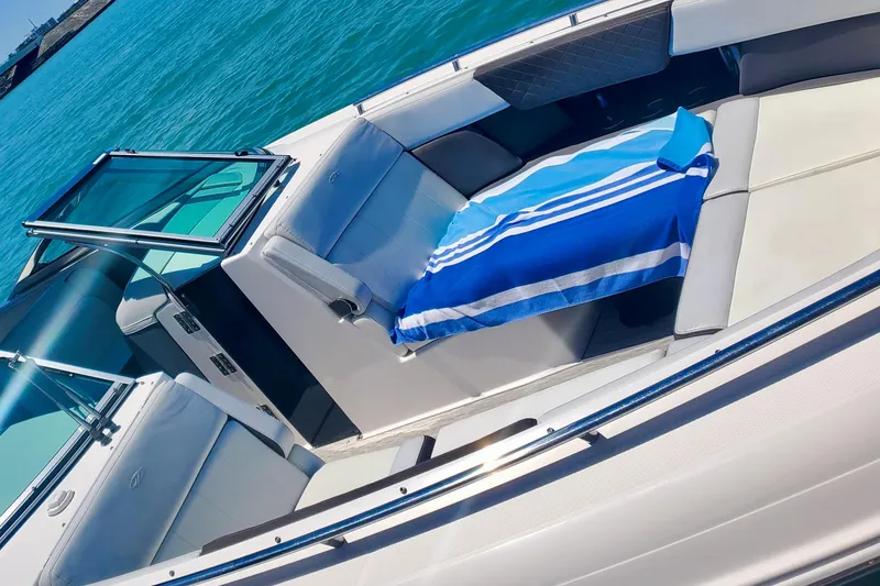 Slide: The Image of 2014 Regal 3200 Bowrider with blue towel, docked on clear water. - 8