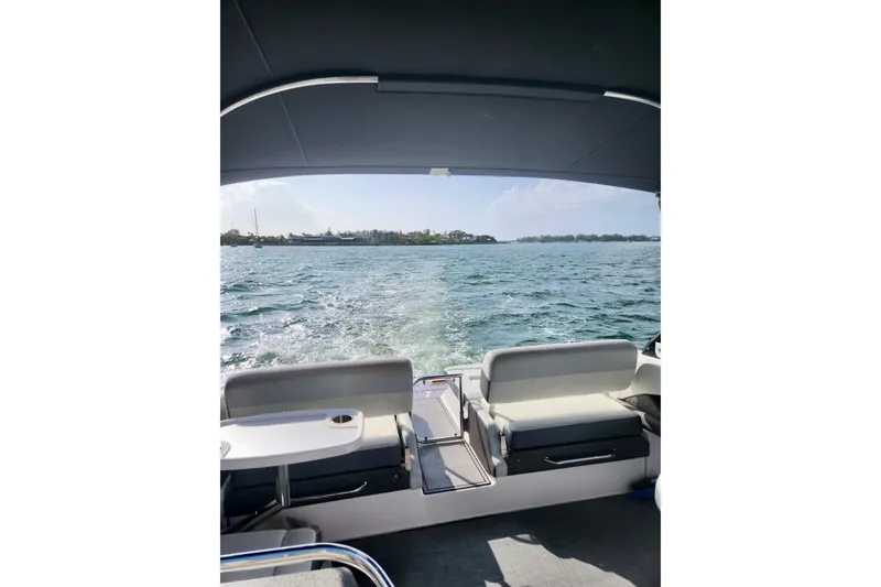 Slide: The Image of 2014 Regal 3200 Bowrider cruising on open water, view from the rear seating area. - 9