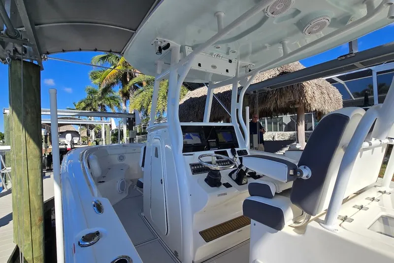 Slide: The Image of 2015 Tidewater 280 CC Adventure boat interior with helm, seats, and tropical background. - 10