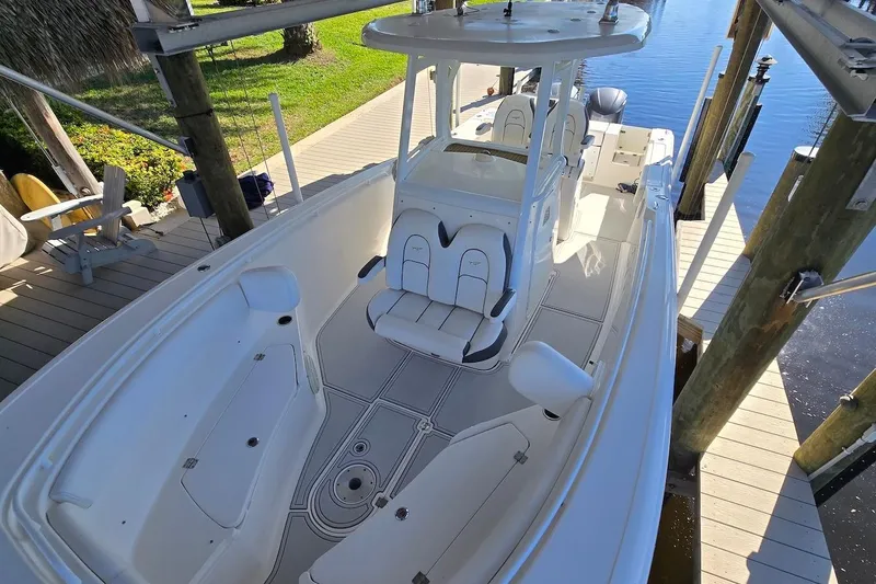 Slide: The Image of 2015 Tidewater 280 CC Adventure boat docked, featuring spacious seating and sleek design. - 16