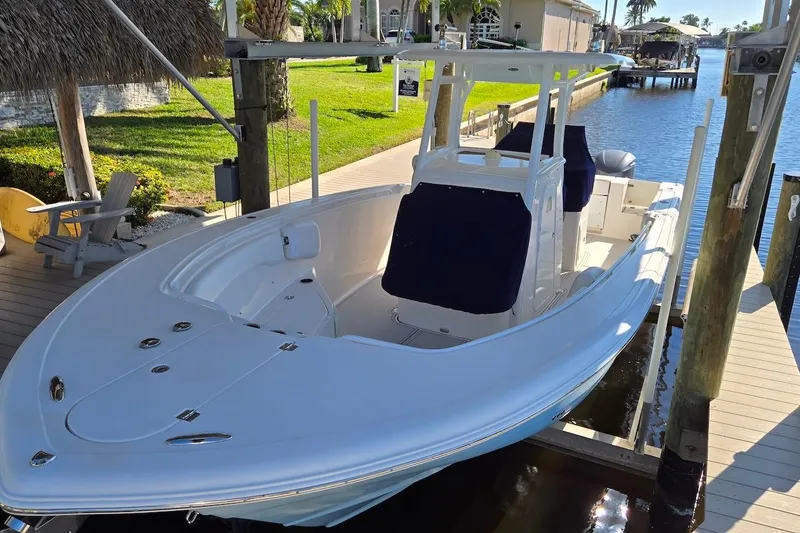 Slide: The Image of 2015 Tidewater 280 CC Adventure boat docked by a canal, featuring sleek design and spacious seating. - 17