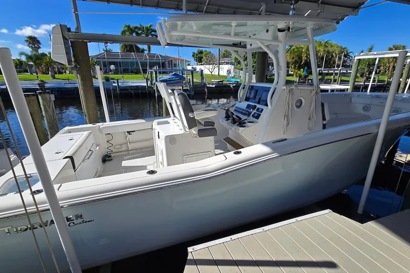 Slide: The Image of 2015 Tidewater 280 CC Adventure boat docked, featuring spacious deck and modern controls. - 2