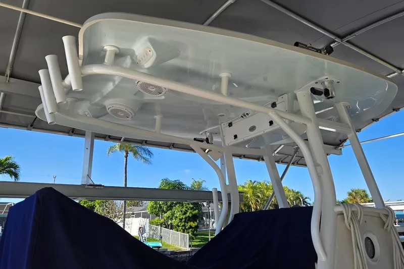 Slide: The Image of Tidewater 280 CC Adventure 2015 boat with T-top and rod holders, docked under cover. - 21