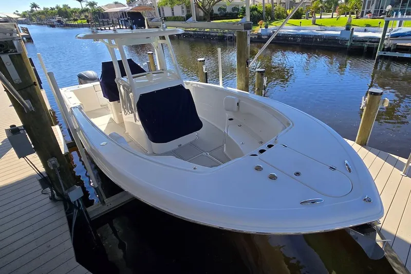 Slide: The Image of 2015 Tidewater 280 CC Adventure boat docked by a scenic waterfront. - 24