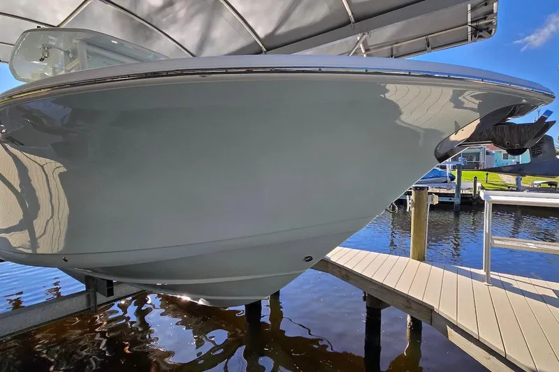 Slide: The Image of 2015 Tidewater 280 CC Adventure boat docked under a canopy on a sunny day. - 3