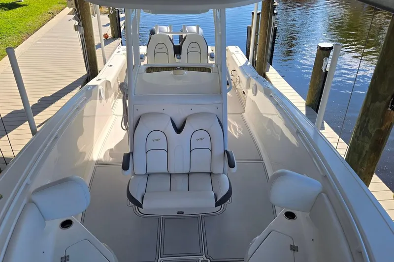 Slide: The Image of 2015 Tidewater 280 CC Adventure boat interior with white seating and helm station. - 6