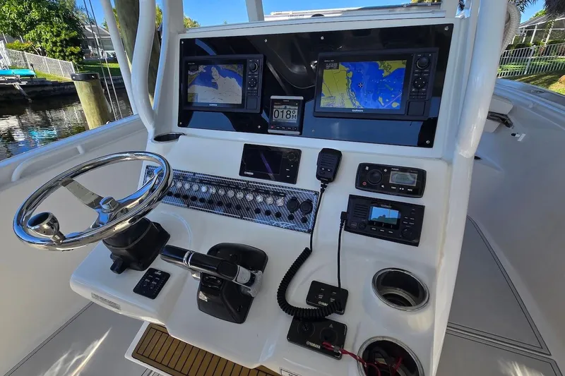 Slide: The Image of 2015 Tidewater 280 CC Adventure boat dashboard with navigation screens and controls. - 7