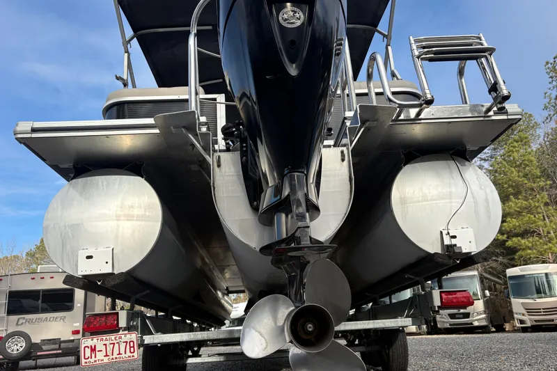 Slide: The Image of 2020 Harris Cruiser 250 pontoon boat on trailer, rear view with motor and propeller. - 22