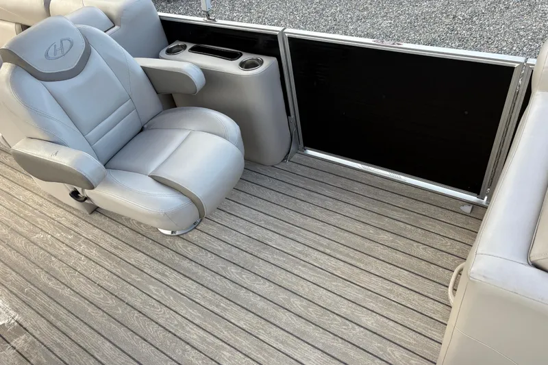 Slide: The Image of 2020 Harris Cruiser 250 boat interior with gray seating and wooden flooring. - 26