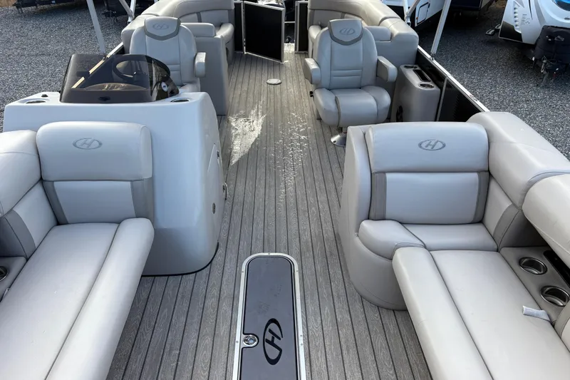 Slide: The Image of 2020 Harris Cruiser 250 pontoon boat interior with gray seating and helm. - 27