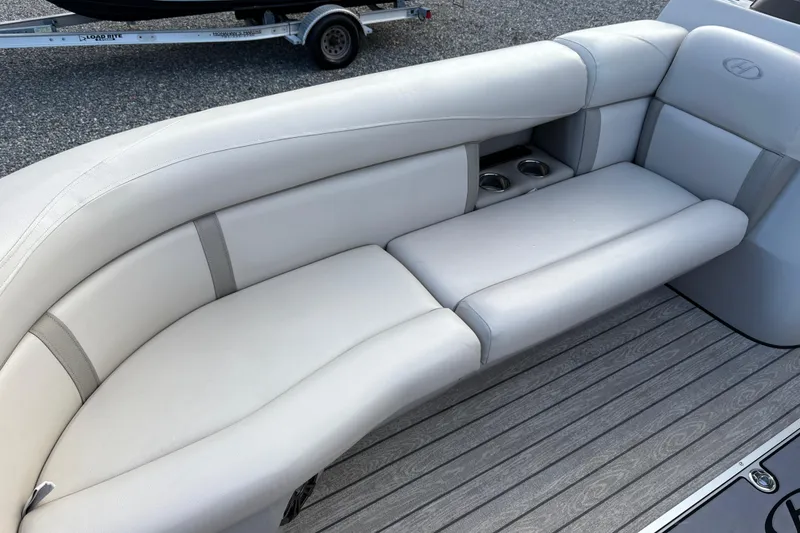 Slide: The Image of 2020 Harris Cruiser 250 boat interior with gray cushioned seating and cup holders. - 28
