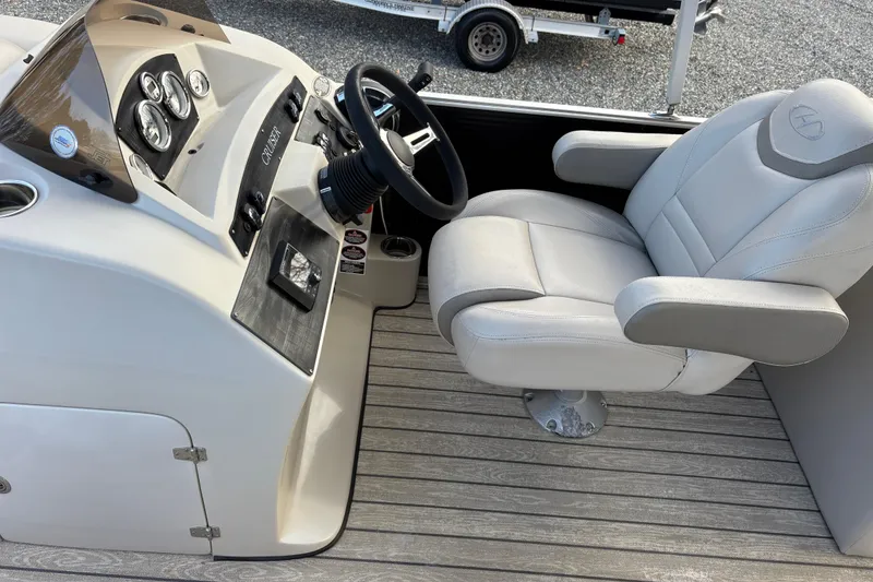 Slide: The Image of 2020 Harris Cruiser 250 boat helm with steering wheel and captain's chair. - 34