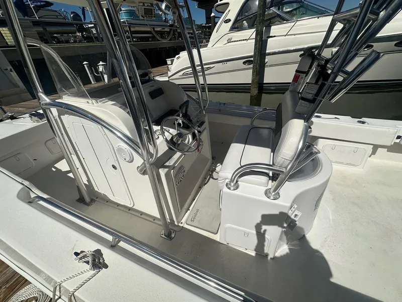Slide: The Image of 2017 Twin Vee 26 GF boat interior with steering console and seating, docked at marina. - 10