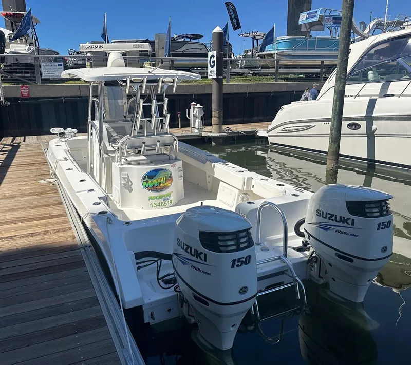 Slide: The Image of 2017 Twin Vee 26 GF boat with twin Suzuki 150 engines docked at marina. - 13