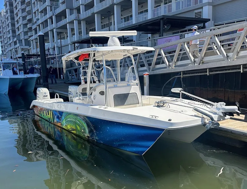 Slide: The Image of 2017 Twin Vee 26 GF boat docked, featuring vibrant hull artwork. - 2