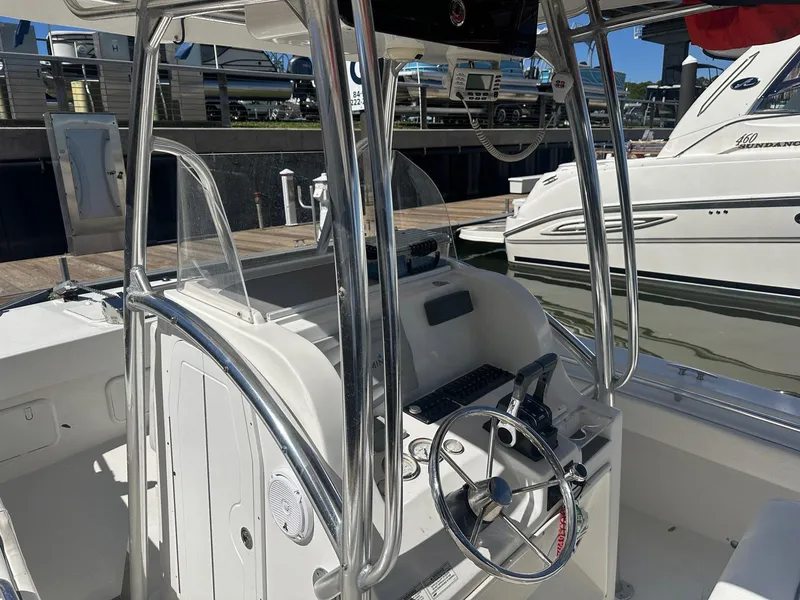 Slide: The Image of 2017 Twin Vee 26 GF boat interior with steering wheel and control panel at dock. - 8