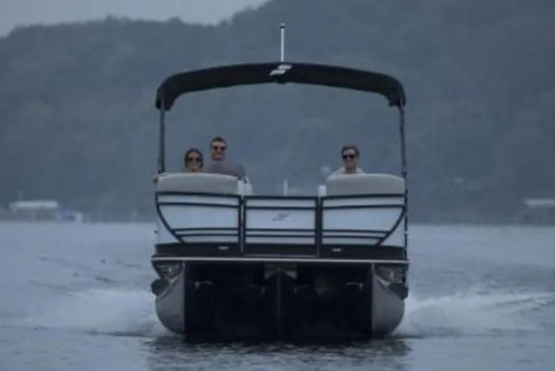 Slide: The Image of 2024 Starcraft SLS 1 pontoon boat cruising on a lake with passengers. - 7