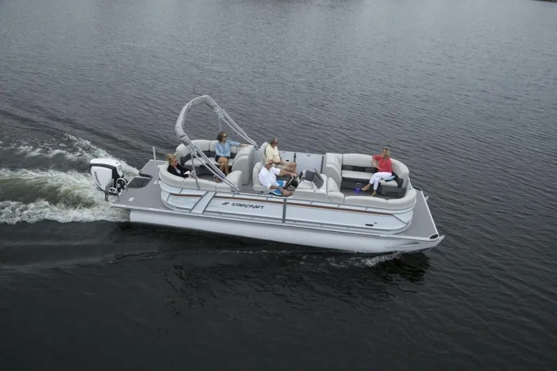 Slide: The Image of 2023 Starcraft SLS 5 pontoon boat cruising on a lake with passengers. - 11
